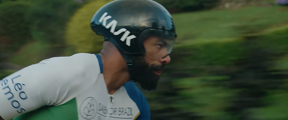 Leo on his time-trial bike in an aero helmet, green fields blurred behind