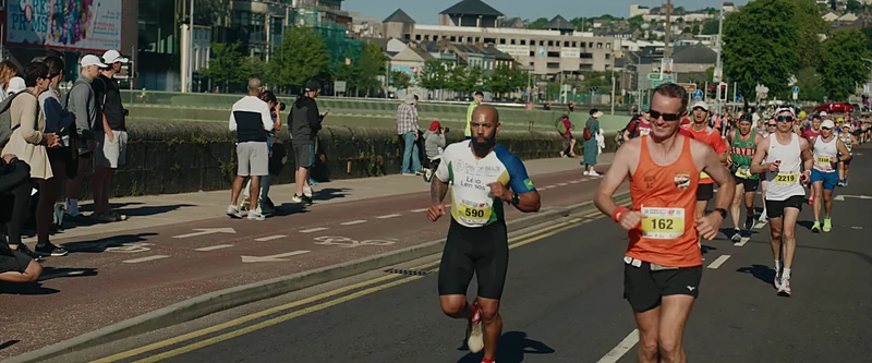 Leo running the Cork City Marathon in a Brazil-coloured top among the crowd