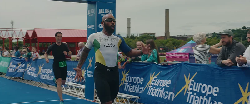 Leo running down the blue finish carpet of the Cork City Triathlon