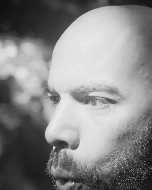 Black and white close portrait of Leonardo Lemos in profile, breathing hard after a run
